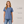 Woman wearing a blue t-shirt with text on fabric type, material, and washability.