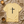 Yellow t-shirt with a black cross and 'FAITH' text on a textured surface with a candle and cup.