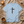 Light blue t-shirt with a black cross and 'FAITH' text on a beige surface with a candle and cup.