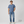 Man wearing a blue t-shirt and jeans on a gray background