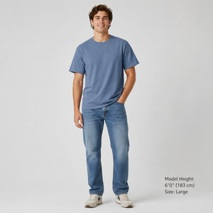 Man wearing a blue t-shirt and jeans on a gray background