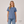 Woman wearing a blue t-shirt and jeans on a plain background